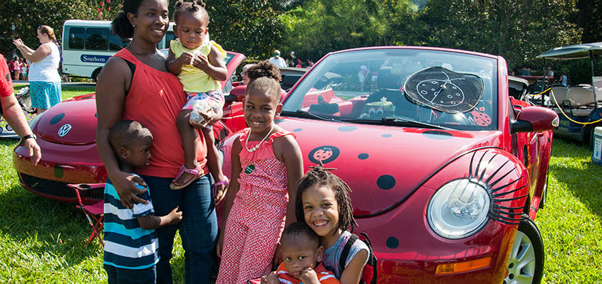 Guests pose in front of one of the VW bugs that delivers the ladybugs to the gardens. &copy; 2016 Audra L. Gibson
